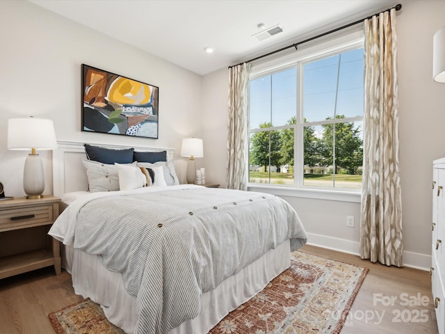 bedroom featuring light wood finished floors, visible vents, recessed lighting, and baseboards