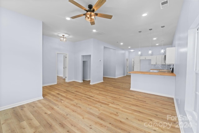 unfurnished living room with light wood-type flooring and ceiling fan