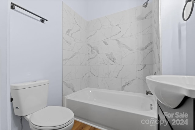 bathroom with tiled shower / bath combo, hardwood / wood-style floors, and toilet