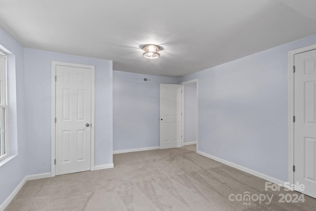 unfurnished bedroom featuring light carpet