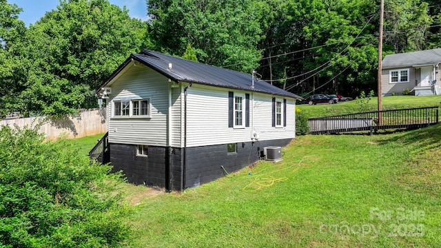 view of home's exterior featuring cooling unit and a lawn