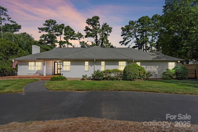 single story home featuring a lawn