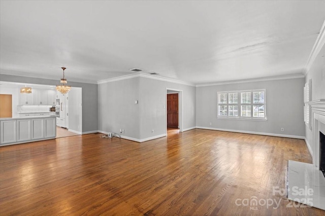 unfurnished living room featuring ornamental molding, light wood-type flooring, and a notable chandelier