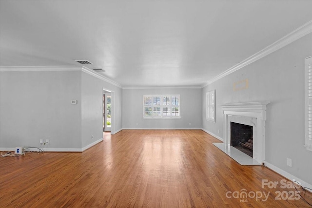 unfurnished living room with ornamental molding, a premium fireplace, and light wood-type flooring