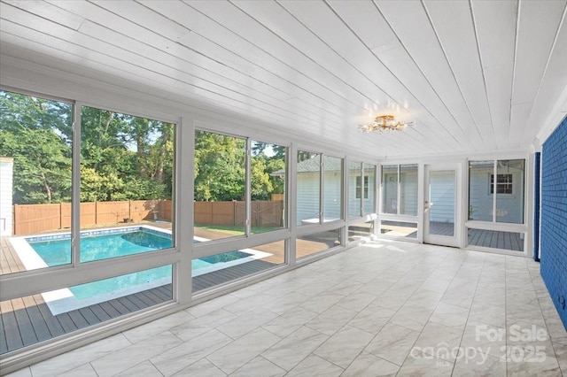 unfurnished sunroom with plenty of natural light and wooden ceiling