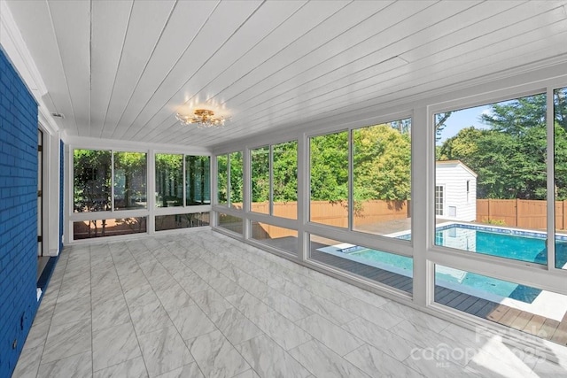 unfurnished sunroom featuring plenty of natural light and wooden ceiling