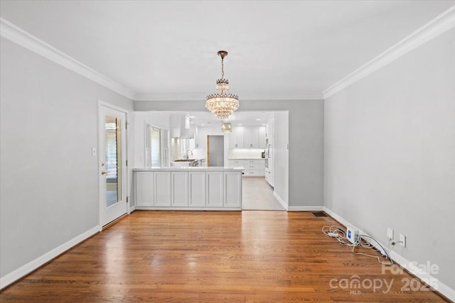 interior space with sink, crown molding, light hardwood / wood-style floors, and a chandelier