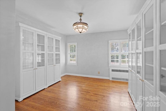 spare room with radiator and light hardwood / wood-style flooring