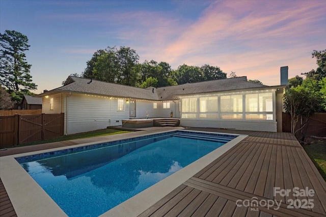 pool at dusk with a sunroom