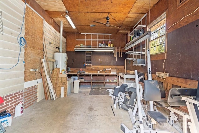 misc room with concrete flooring, a workshop area, water heater, and ceiling fan