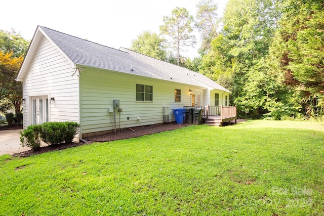 rear view of house featuring a yard and a deck