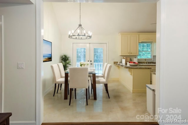 dining room with lofted ceiling, french doors, an inviting chandelier, and sink