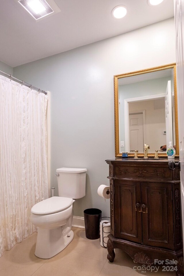 bathroom featuring vanity, toilet, and curtained shower