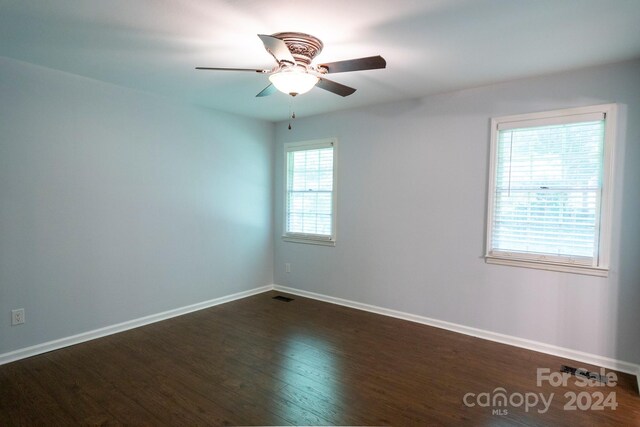 spare room with dark wood-type flooring and ceiling fan