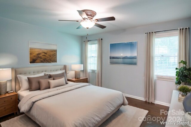 bedroom with dark wood-type flooring, ceiling fan, and multiple windows