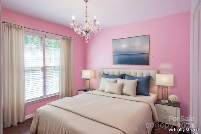 bedroom with dark wood-type flooring and a chandelier