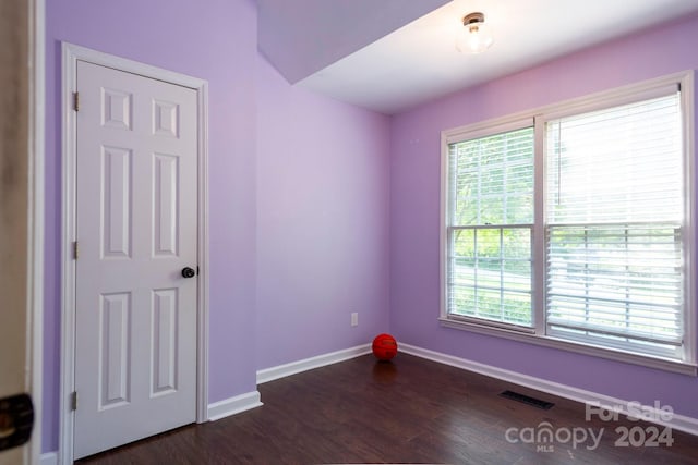 unfurnished room featuring dark hardwood / wood-style flooring and a wealth of natural light