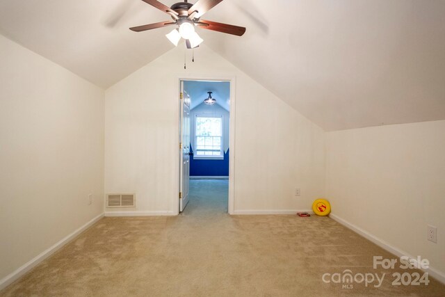 additional living space featuring ceiling fan, light colored carpet, and vaulted ceiling