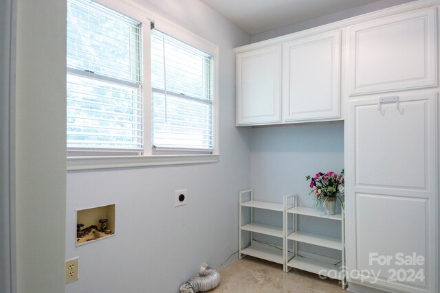 clothes washing area with washer hookup, cabinets, and hookup for an electric dryer