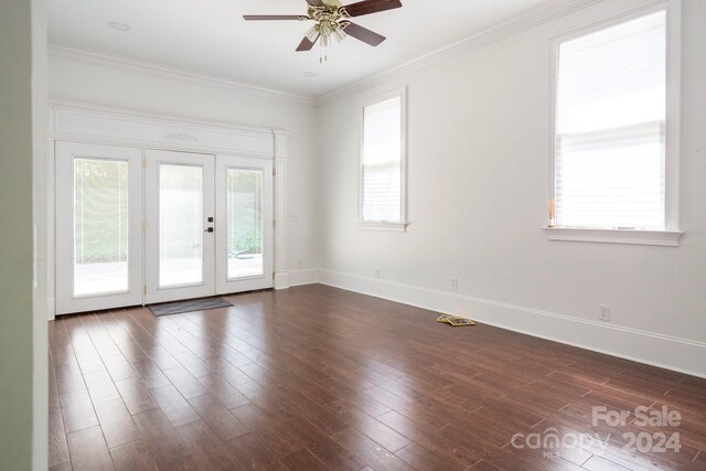 empty room featuring dark wood-type flooring, ceiling fan, ornamental molding, and french doors