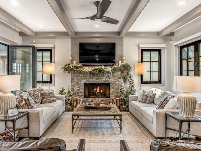 living room featuring a fireplace, beam ceiling, and ceiling fan