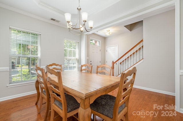 dining area featuring wood-type flooring, an inviting chandelier, and a healthy amount of sunlight