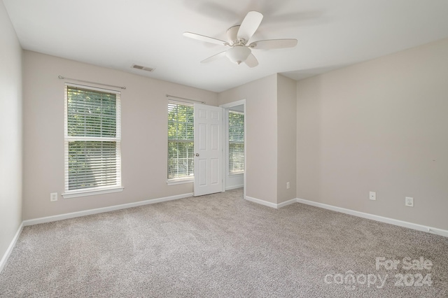 carpeted spare room featuring ceiling fan