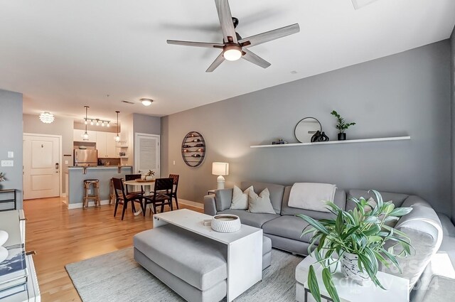 living room featuring light wood-type flooring and ceiling fan