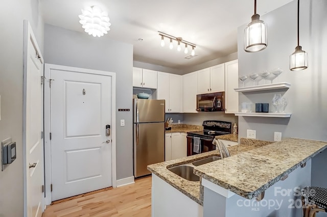 kitchen with kitchen peninsula, black appliances, pendant lighting, and rail lighting