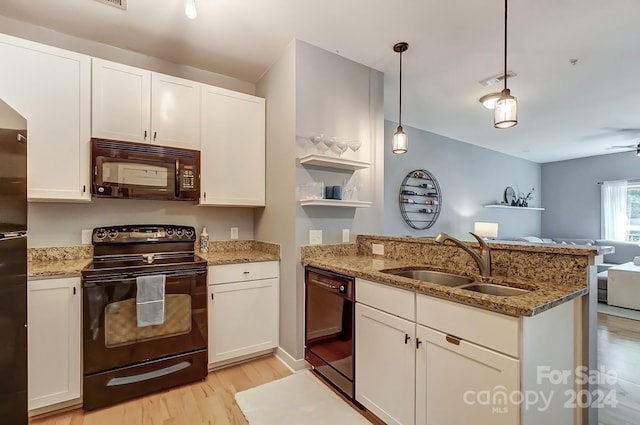 kitchen featuring black appliances, white cabinets, sink, light wood-type flooring, and light stone countertops