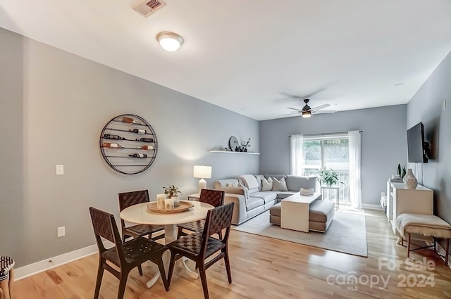 dining area with light hardwood / wood-style flooring and ceiling fan