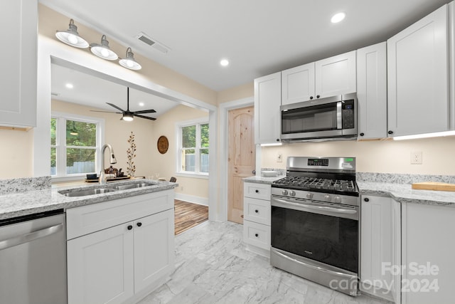 kitchen featuring light stone countertops, sink, white cabinets, and appliances with stainless steel finishes