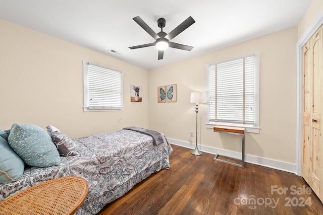 bedroom featuring ceiling fan, dark hardwood / wood-style floors, and a closet