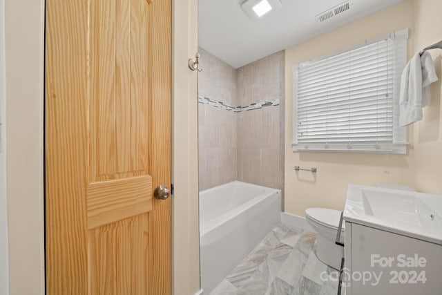 full bathroom with toilet, vanity, and tiled shower / bath