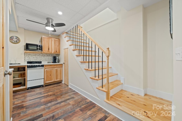 kitchen featuring light brown cabinets, dark hardwood / wood-style flooring, backsplash, white range oven, and a drop ceiling