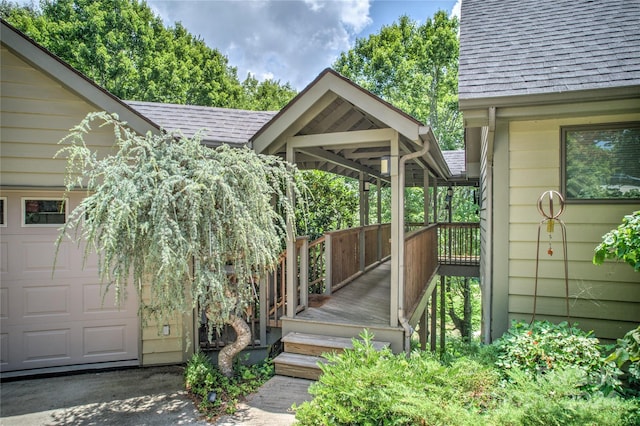 property entrance with roof with shingles and a garage