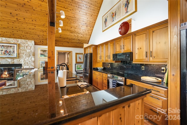 kitchen featuring a sink, open floor plan, dark countertops, appliances with stainless steel finishes, and high vaulted ceiling