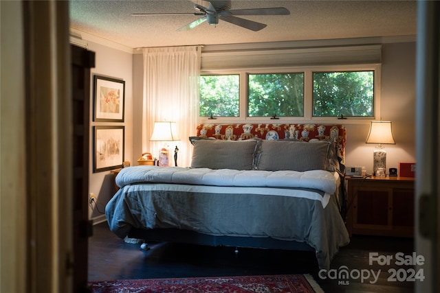 bedroom with ornamental molding, a ceiling fan, wood finished floors, and a textured ceiling
