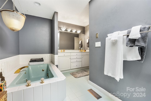 bathroom featuring visible vents, tile patterned floors, a whirlpool tub, and vanity