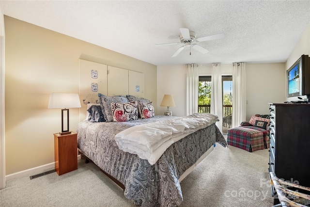 bedroom with carpet floors, access to outside, visible vents, and a textured ceiling