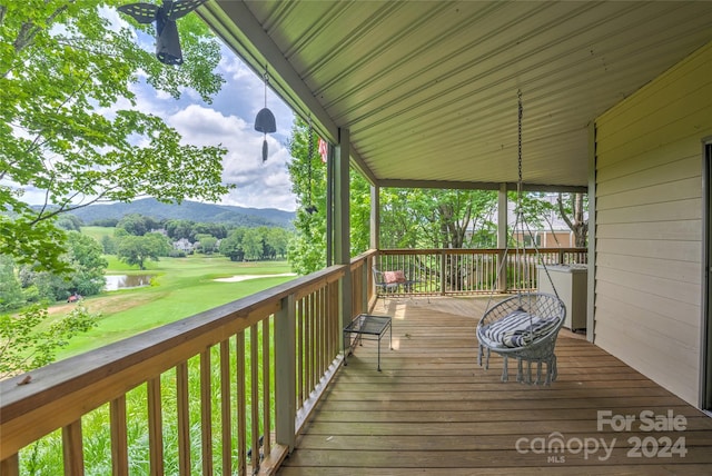 wooden deck with a water and mountain view