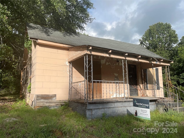 exterior space featuring a porch and roof with shingles