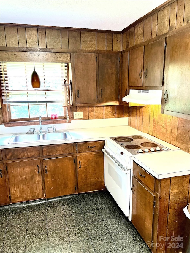 kitchen featuring sink, wooden walls, and white range with electric cooktop