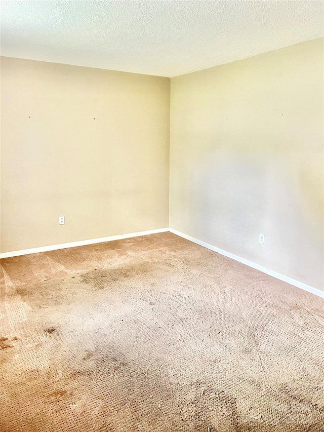 carpeted spare room featuring a textured ceiling