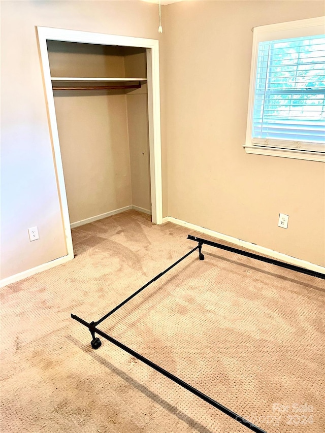 unfurnished bedroom featuring carpet floors and a closet