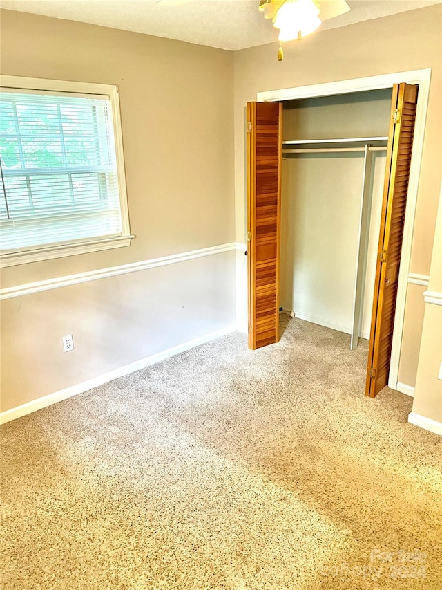 unfurnished bedroom featuring carpet and a closet