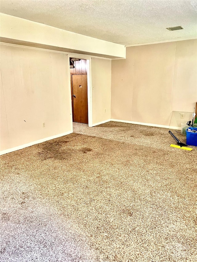 empty room with carpet floors and a textured ceiling