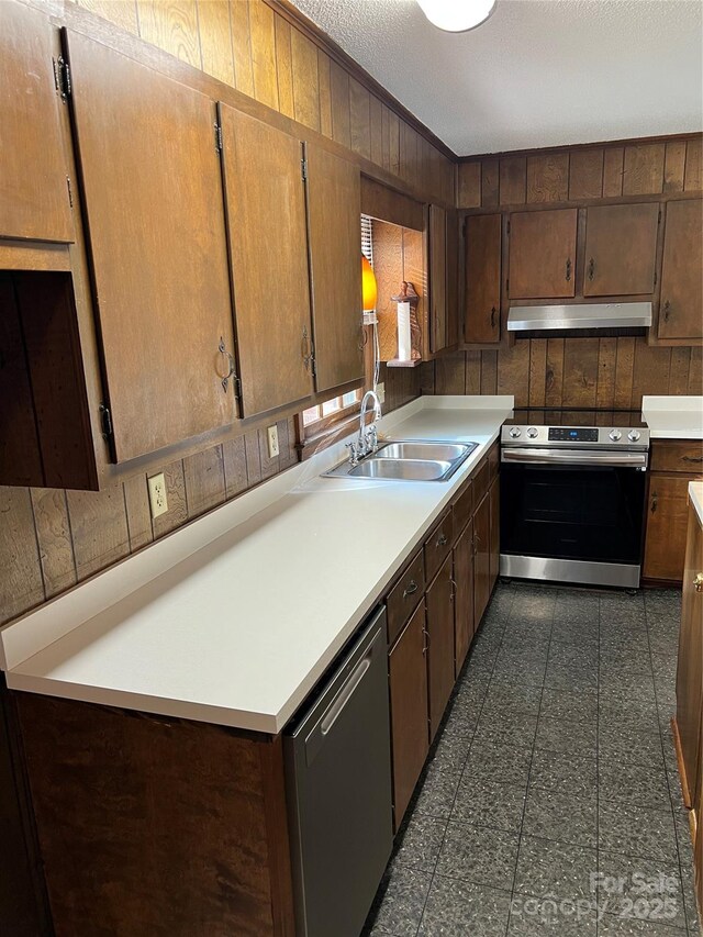 1111 S Skyland Dr, Mount Pleasant, NC 28124 - kitchen with a sink, wood walls, under cabinet range hood, and stainless steel appliances