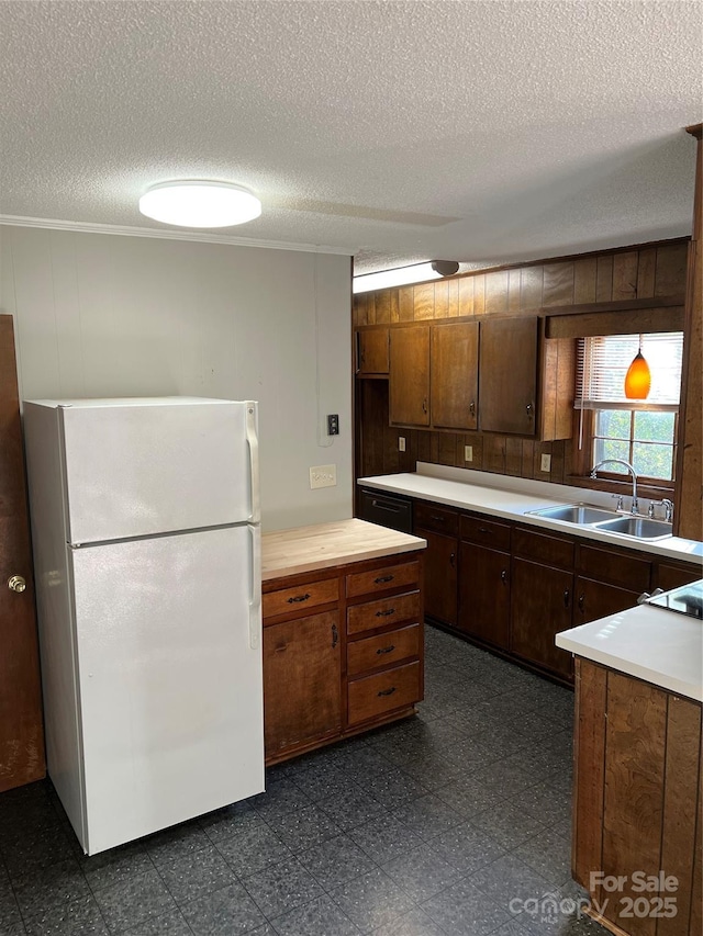1111 S Skyland Dr, Mount Pleasant, NC 28124 - kitchen featuring freestanding refrigerator, a textured ceiling, ornamental molding, a sink, and wooden walls