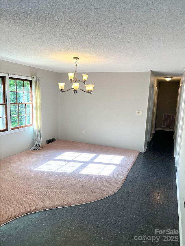 1111 S Skyland Dr, Mount Pleasant, NC 28124 - unfurnished room with a notable chandelier, visible vents, a textured ceiling, and dark floors